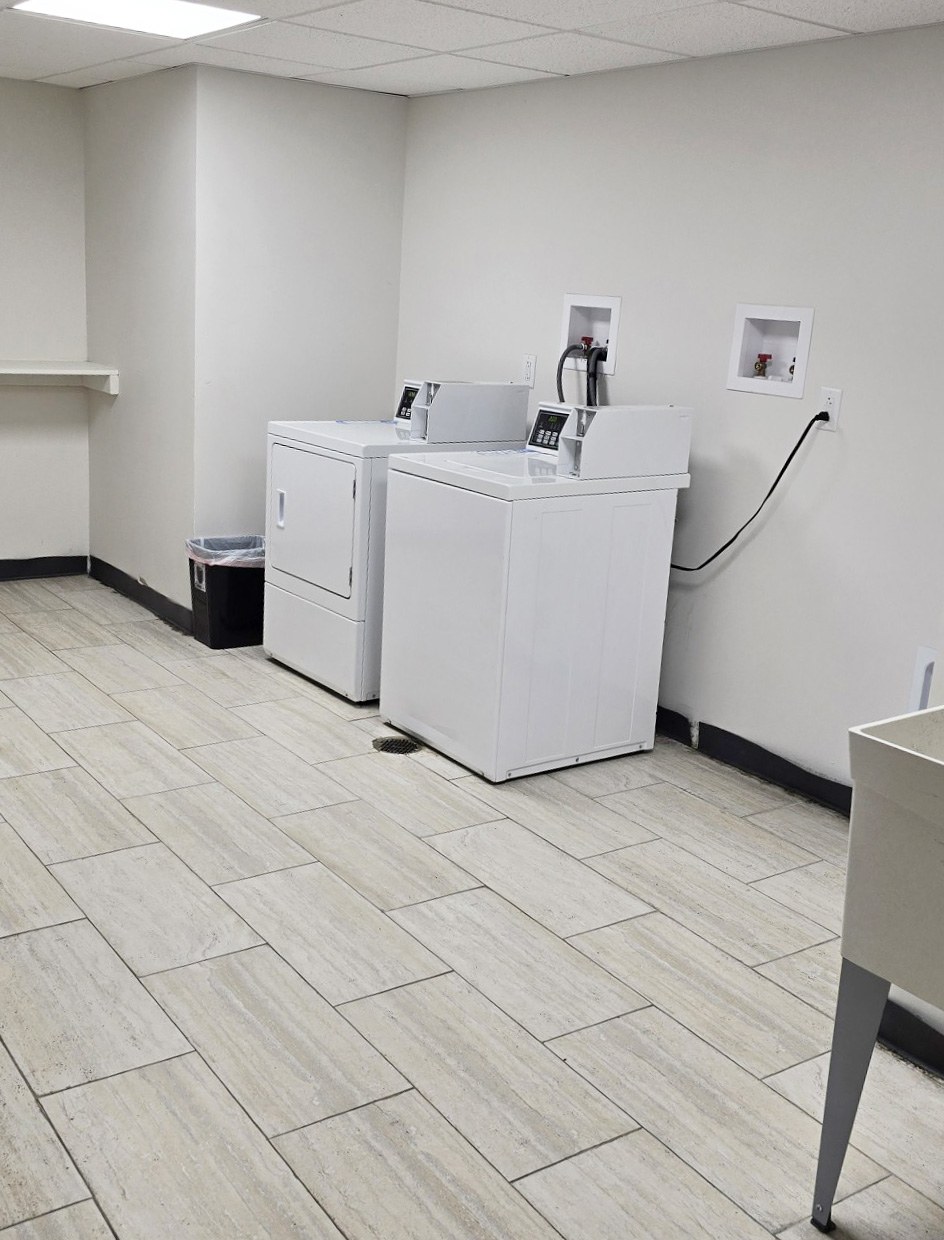 A white sink is in a room with a tiled floor.